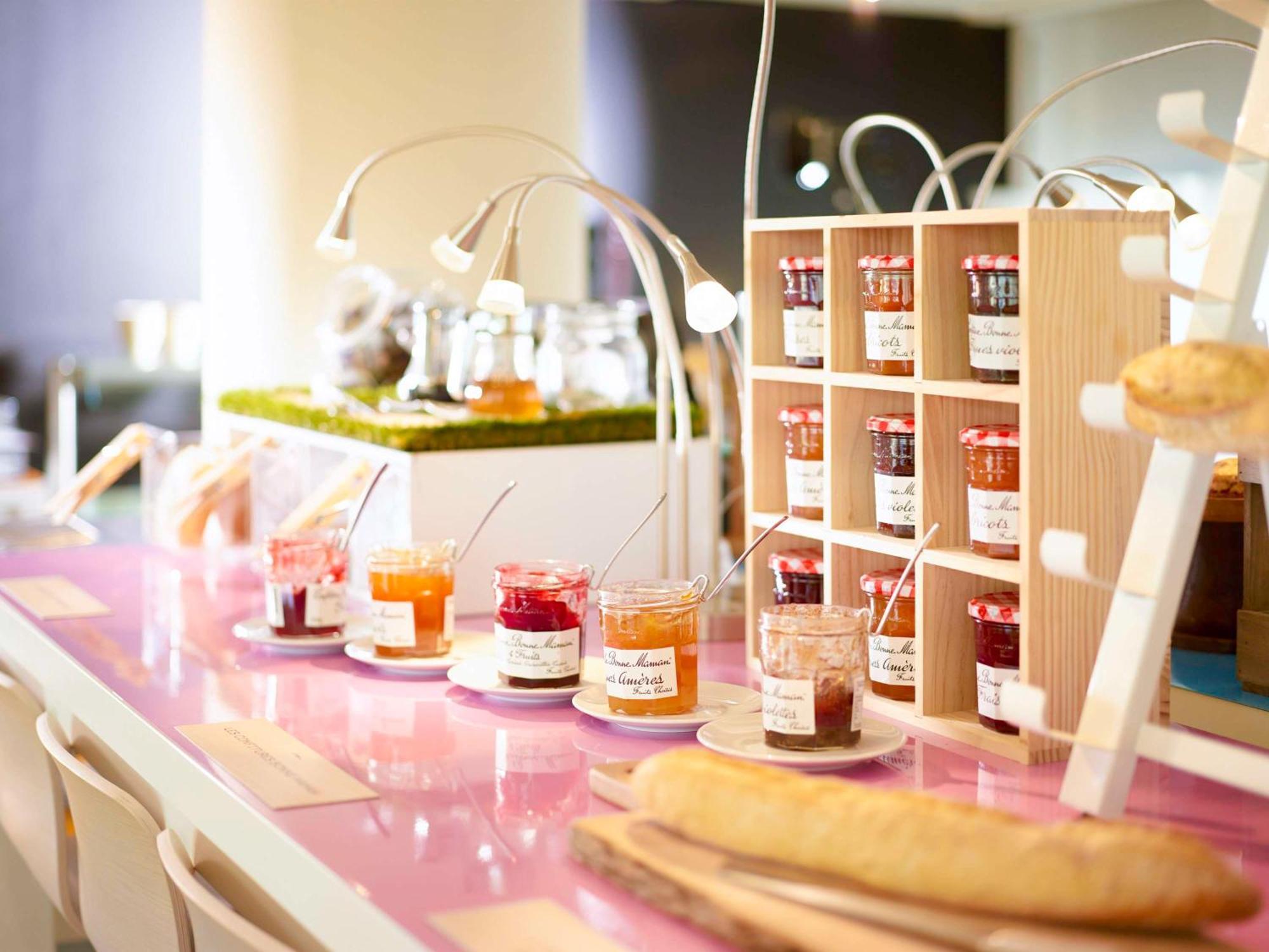 Hyatt Regency Taoyuan International Airport Hotel Exterior photo The photo shows a breakfast setup featuring a variety of jars filled with different types of jams or spreads. These jars are neatly arranged on a countertop, with each label indicating their contents. In the background, there is a display of small gl