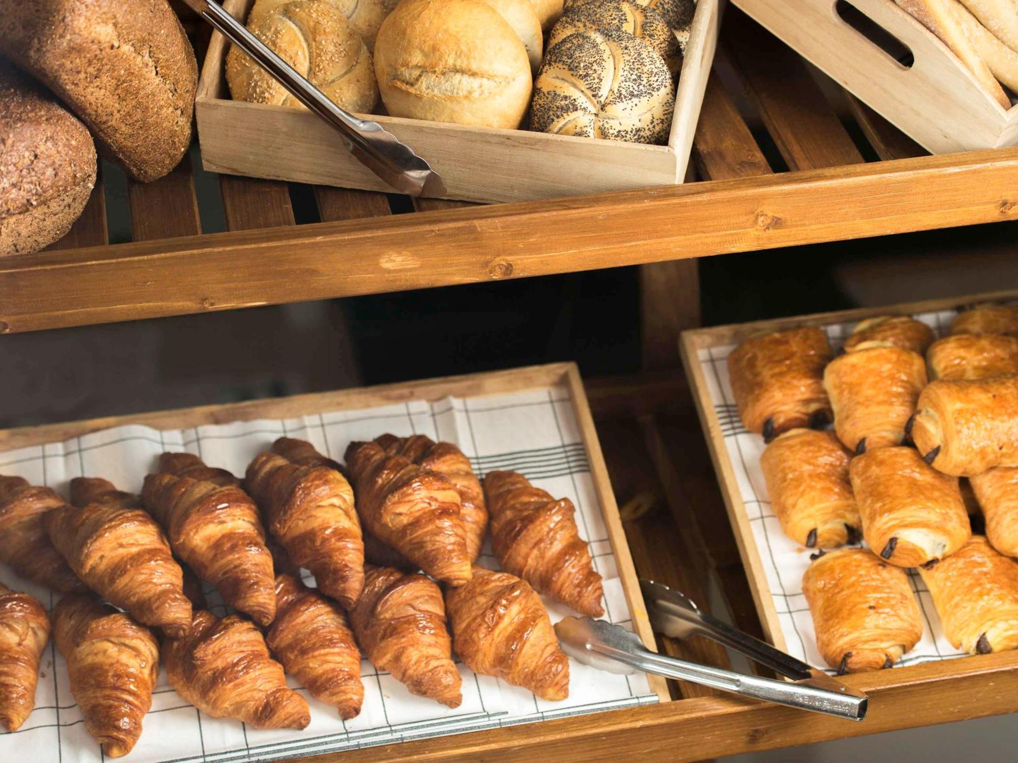 Hyatt Regency Taoyuan International Airport Hotel Exterior photo The photo displays an assortment of baked goods. On one tray, there are several golden-brown croissants, characterized by their flaky texture and layered appearance. Beside them, another tray features additional pastries, possibly including chocolate